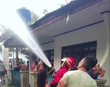 Petugas Pos Damkar VI Cisaat sigap padamkan api yang melalap habis rumah kontrakan di Kampung Sukamanah, Cisaat.