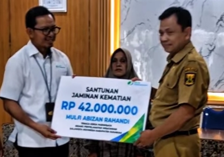 Kepala Dinas Pariwisata Kabupaten Sukabumi menyerahkan santunan Jaminan Kematian dari BPJS